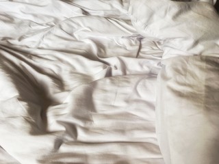 Wrinkle white soft blanket on the bed after wake up in the morning.