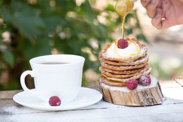 A stack of delicious pancakes with honey and blueberries on a wood background. with copy space