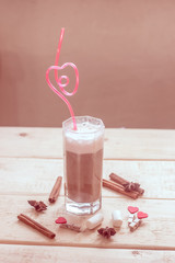Coffee with milk in a glass with a pink tube.
