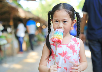 Obraz premium Adorable little Asian child girl enjoy eating colorful Thai style ice cream.