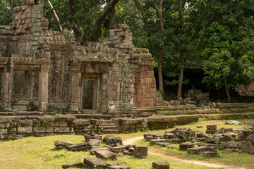 Fototapeta na wymiar Stone temple with fallen blocks covering lawn