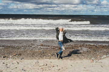 girl walking along the beach of the cold Baltic Sea