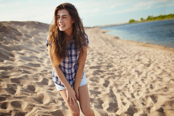 Brunette girl posing for photo on the sand beach