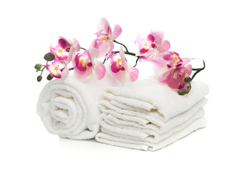 Obraz na płótnie Canvas Stack of clean soft towels with orchid flower on white background - Image.