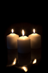 candles with reflection burning on black background with copy space