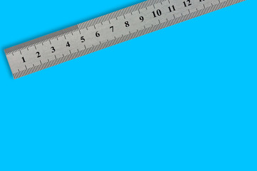 Single metal straightedge with digits and scale on blue background with copy space for your text