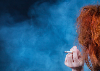 a woman with red hair smokes a cigarette