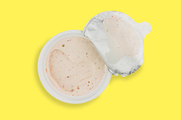 Single plastic jar of pate in center of yellow background