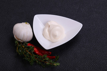 Mayonnaise sauce in the white bowl served thyme and garlic