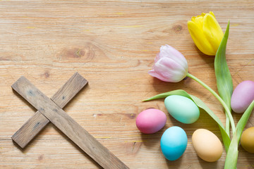 Fototapeta na wymiar Easter eggs and cross on abstract wooden spring background