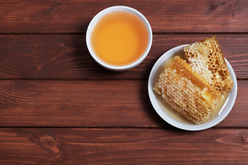 Beautiful sweet honey with honeycombs on the background. Place for text. Top view, flat lay.