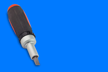 One ratchet screwdriver with orange and black plastic with rubber handle and bit on blue background with copy space for your text. Building or repair concept