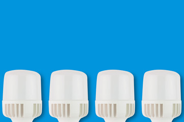 Row of new plastic led bulbs on blue background with copy space for your text. Saving and economy...