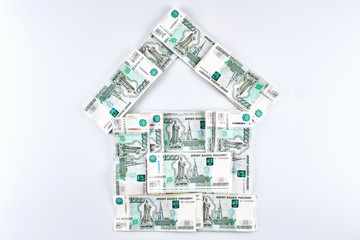 Rubles. Russian money in the shape of a house on a white background. Real estate loan concept