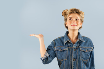 Young beautiful strongly emotional girl shows different gestures on an isolated blue background....