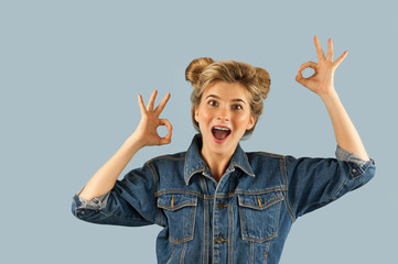 Young beautiful strongly emotional girl shows different gestures on an isolated blue background. Concept of human emotions