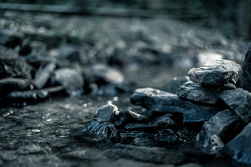 Fototapeta na wymiar close up of stone that use to make weir in river with water steam flowing, made in dramatic tone