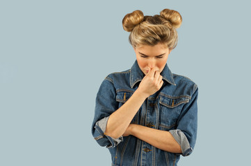 Young beautiful strongly emotional girl shows different gestures on an isolated blue background....