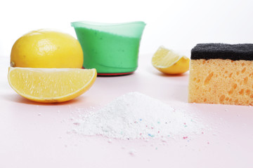 Flat lay composition with lemon, washcloth, soap, powder on a pink background. Free space for text. Top view.