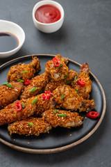 Chicken nuggets with sauce and pepper on a dark background. Copy space.
