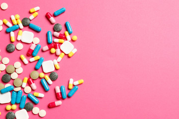Multi-colored vitamins on a pink background. Place for text. Top view.