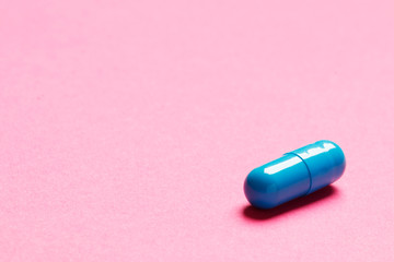 Blue pill on pink background. Place for text. Top view.