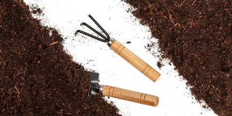 Garden tools in soil isolated on white background . Top view