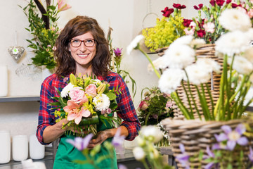 Freudig lächelnde Floristin mit frisch gebundenem Valentinsstrauß