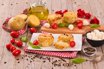 Potato gratins with mozzarella and tomatoes.