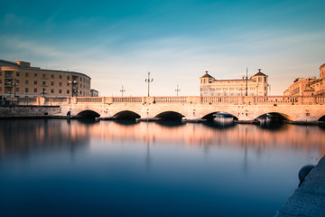 Fototapeta premium Ortigia, Syracuse, Italy / December 2018: View of the strait of water between mainland Siracusa and Ortigia. View of Umberto I bridge in Syracuse