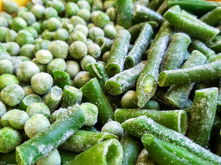 Green frozen beans and peas. Closeup frozen cut green french bean, haricot vert. Vegetable food background, healthy vegetarian natural nutrition.