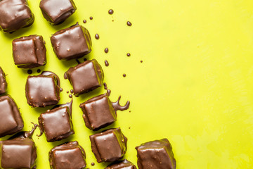 Cookies in chocolate icing on a yellow background. 