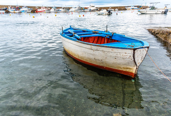 Fototapeta na wymiar Small Old Fishing Boat in a Harbor on the Southern Mediterranean Coast of Italy