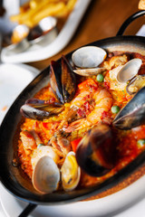 Spanish paella in a serving pan on a table in a cafe