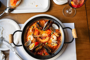 Spanish paella in a serving pan on a table in a cafe, close-up