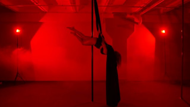Adult sexy woman dancing dance in an intimate setting. Silhouette of a sexy woman dancing on red background. Pole dance from an old woman