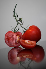 Two red ripe tomatoes are lying on the table