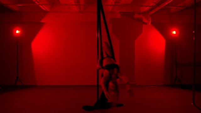 Adult sexy woman dancing dance in an intimate setting. Silhouette of a sexy woman dancing on red background. Pole dance from an old woman