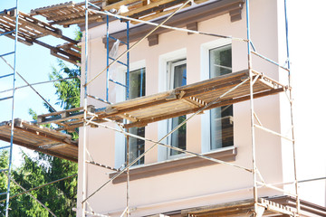 Painting and Plastering Exterior House Scaffolding Wall. Home Facade Insulation, Sctucco and...