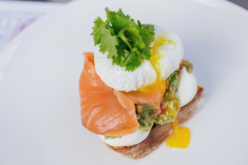 Toast with guacamole, salmon and poached egg.