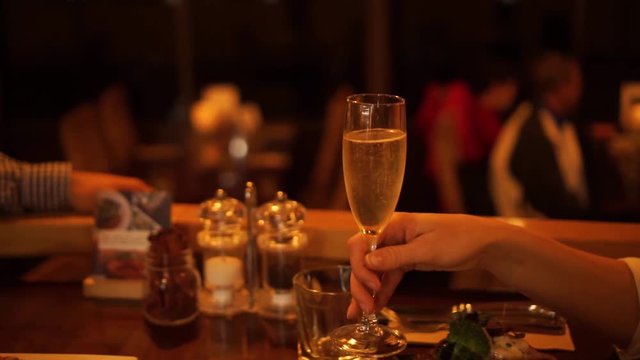 SLOWMO - Couple in luxury restaurant cheers with glasses of champagne