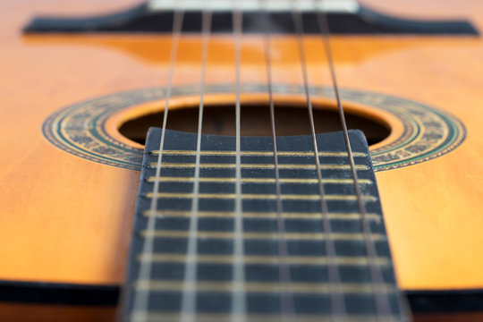 Closeup wooden classical guitar. Old classical guitar with nylon strings. Old acoustic guitar