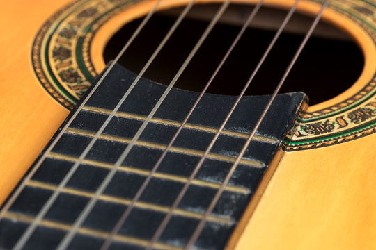Closeup wooden classical guitar. Old classical guitar with nylon strings. Old acoustic guitar