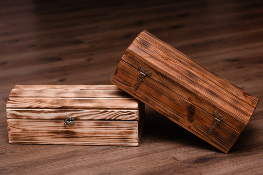 Two closed wooden luxury gift boxes or caskets on wood background.