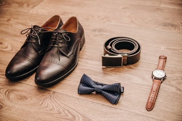 belt, shoes, butterfly, watch, men's attributes of clothing on an isolated wooden background