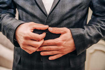 young man buttoning a button on his jacket
