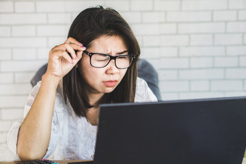 Asian woman worker with eye vision  problem try to watch on computer screen