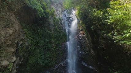 Fototapeta na wymiar aerial view waterfall in green rainforest. tropical waterfall in mountain jungle. Bali,Indonesia. Travel concept.