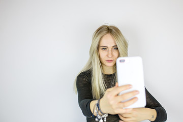 Naklejka premium Modern blonde takes a selfie on the phone