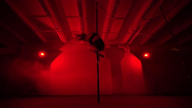 Adult sexy woman dancing dance in an intimate setting. Silhouette of a sexy woman dancing on red background. Pole dance from an old woman